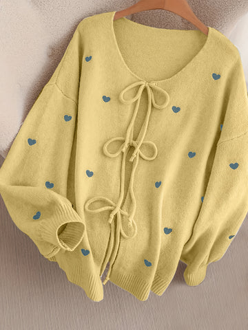 Gemütlicher beigefarbener Pullover mit Herzschleife