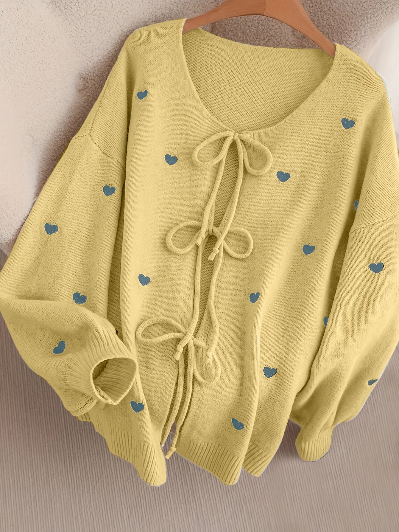 Gemütlicher beigefarbener Pullover mit Herzschleife